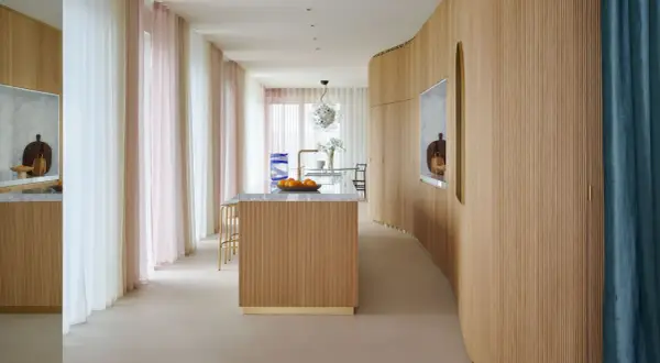 Ingresso con boiserie moderne in legno, isola cucina e tende colorate.