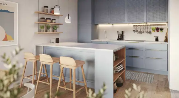 Accogliente piccola cucina con isola a muro, sgabelli in legno e pensili azzurri.
