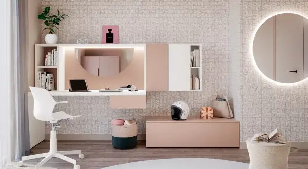 Moderna postazione trucco con specchio rotondo illuminato, scrivania bianca e rosa, sedia, cestini e decorazioni.