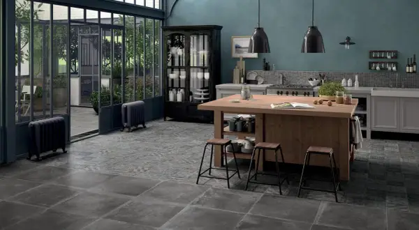 Cucina con isola in legno, sgabelli, vetrata e pavimenti con idee piastrelle cucina effetto pietra e decoro vintage.