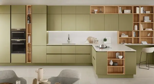 Elegante cucina verde e legno con isola, pensili a giorno e zona studio integrata.