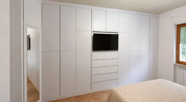 Armadio a muro bianco con TV integrata e specchio, perfetto per idee armadio camera da letto piccola.