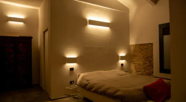 Moderne idee illuminazione led soggiorno: applique a parete creano un'atmosfera calda e accogliente attorno al letto.