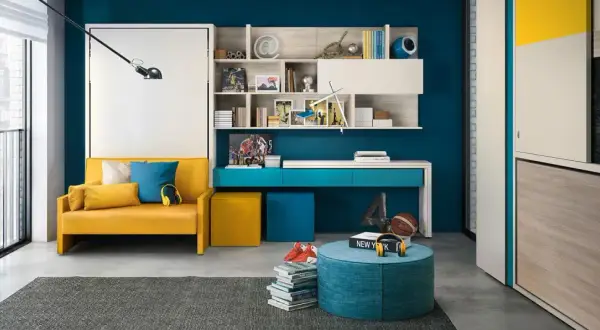 Camera ragazzo 14 anni: divano giallo, scrivania blu, libreria con oggetti sportivi e una lavagna con la scritta "Follow your instincts".