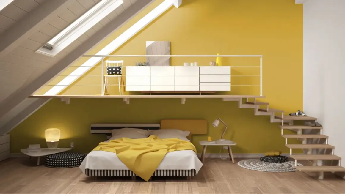 Camera da letto moderna con pareti in varie tonalità di giallo, un letto con coperta gialla e una scala a vista.