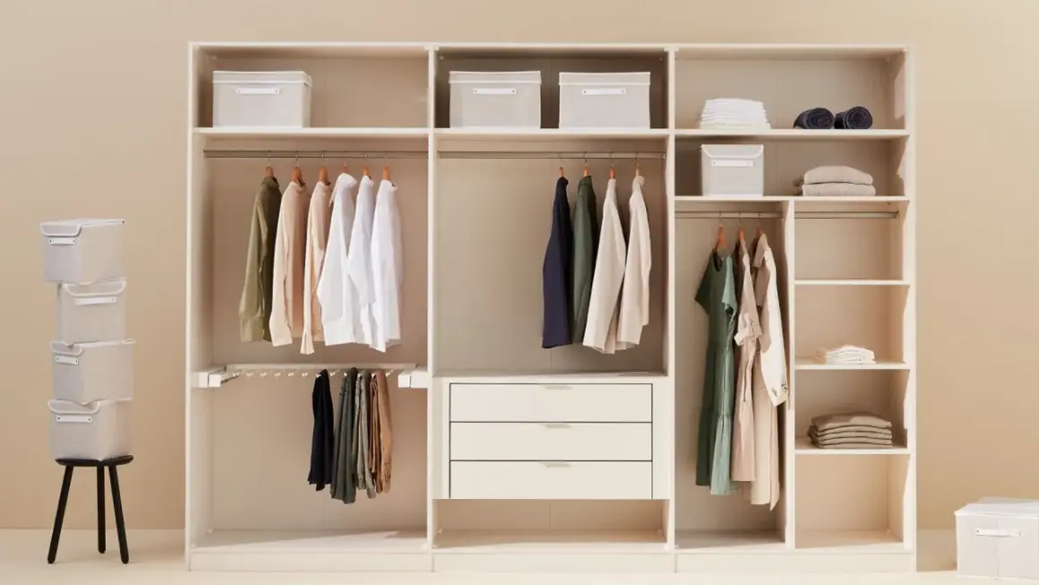 Un armadio bianco ben organizzato con vestiti appesi, scatole contenitive e cassetti.