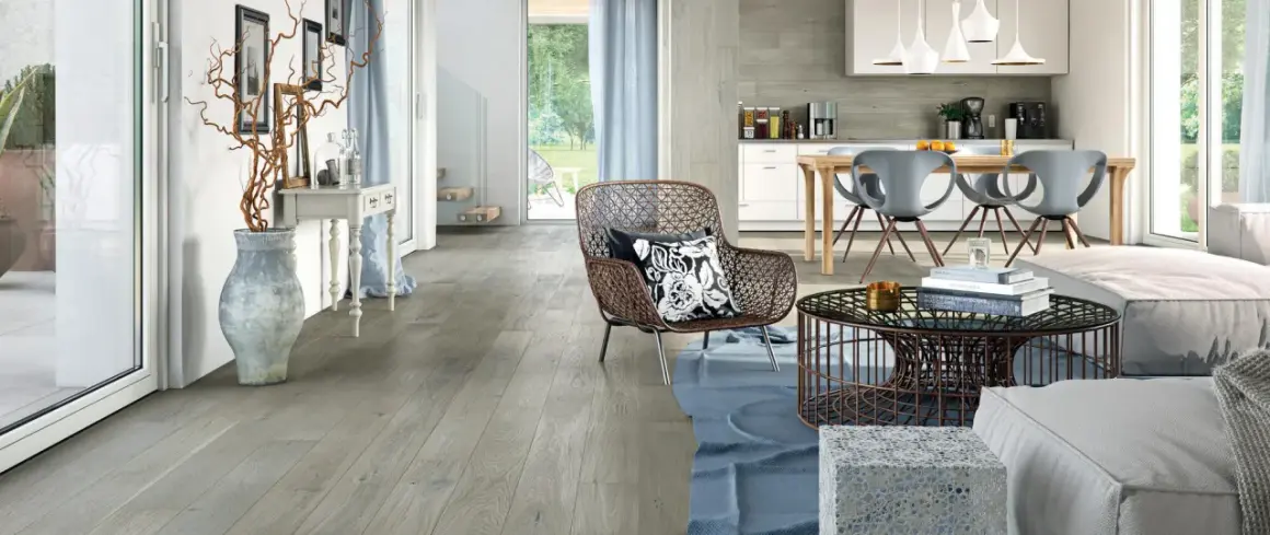 Soggiorno e cucina moderni con pavimento grigio chiaro, mobili di design e un'ampia vetrata sul giardino.