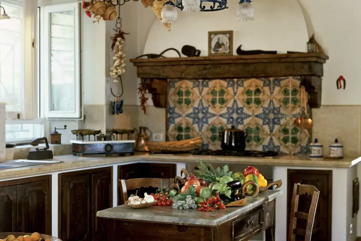 Cucine montagna piccole con un ricco tavolo di verdure fresche. Pareti decorate con maioliche colorate e dettagli rustici.