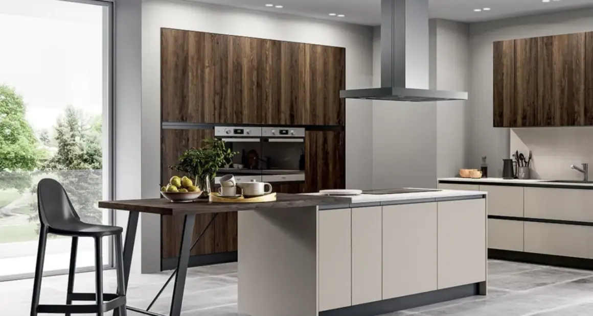 Elegante cucina grigio e legno con isola centrale, bancone snack e vista sul verde.