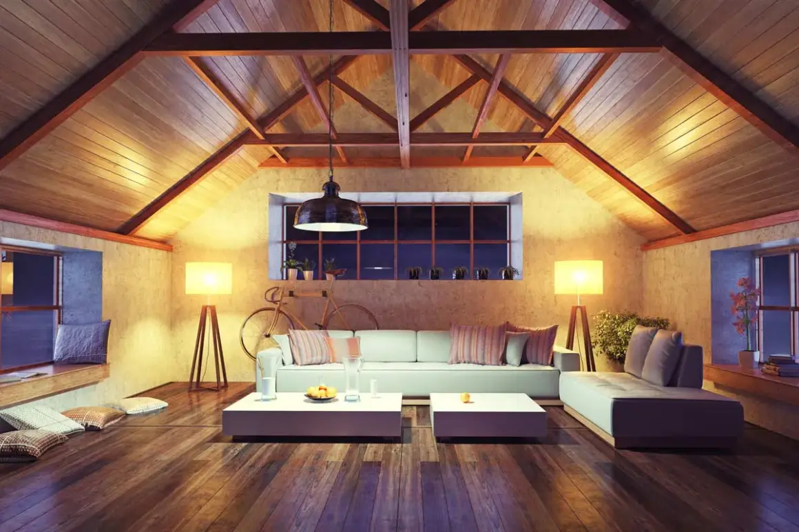 Accogliente soggiorno mansardato con travi a vista e illuminazione calda. Ottime idee sottotetto molto basso per creare un ambiente confortevole.
