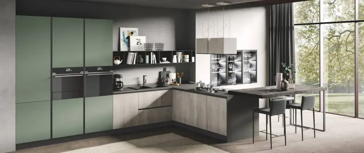 Elegante cucina due colori con ante verdi e finitura legno, isola con sgabelli e vista su un giardino lussureggiante.