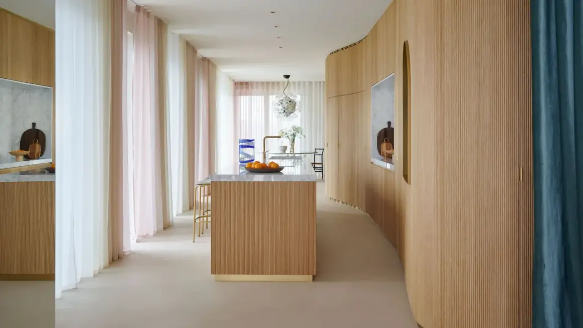 Ingresso con boiserie moderne in legno, isola cucina e tende colorate.