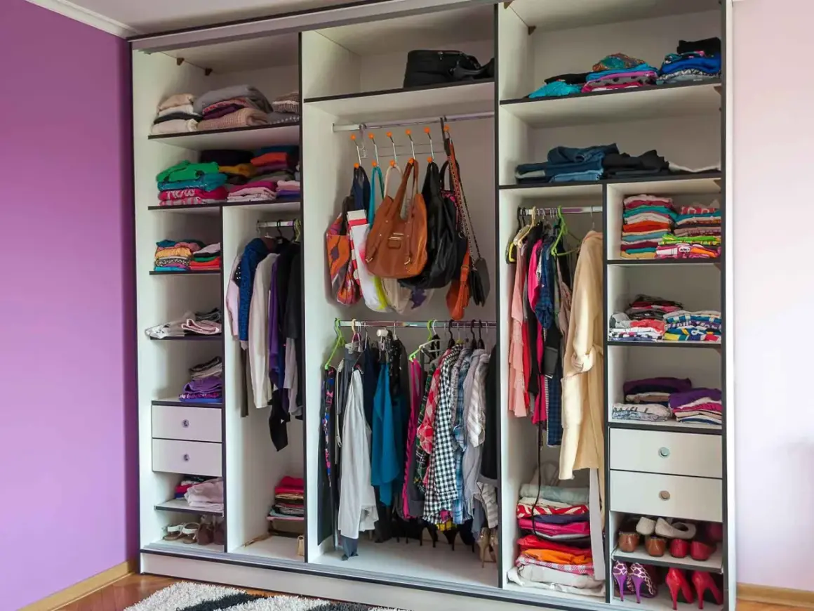 Armadio camera da letto con abiti piegati e appesi, borse e scarpe. I colori vivaci dei vestiti creano un arcobaleno.