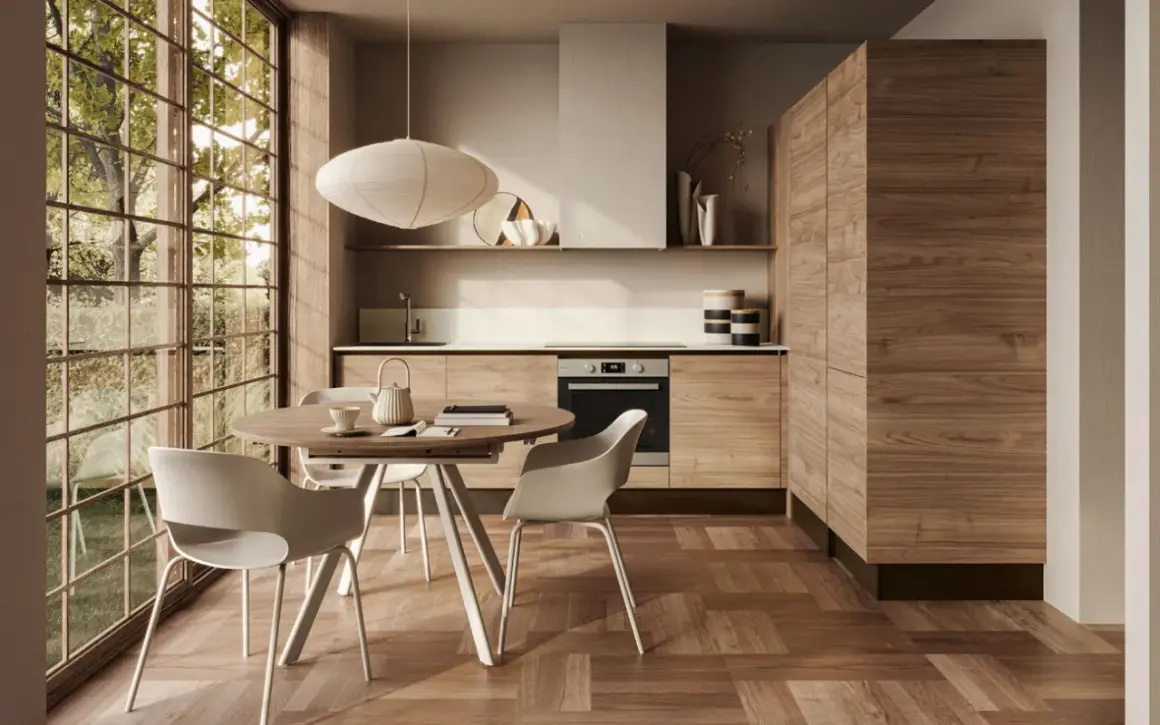 Ecco come arredare una cucina moderna: mobili in legno, tavolo rotondo con sedie bianche e grande finestra con vista sul verde.