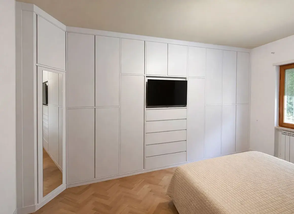 Armadio a muro bianco con TV integrata e specchio, perfetto per idee armadio camera da letto piccola.