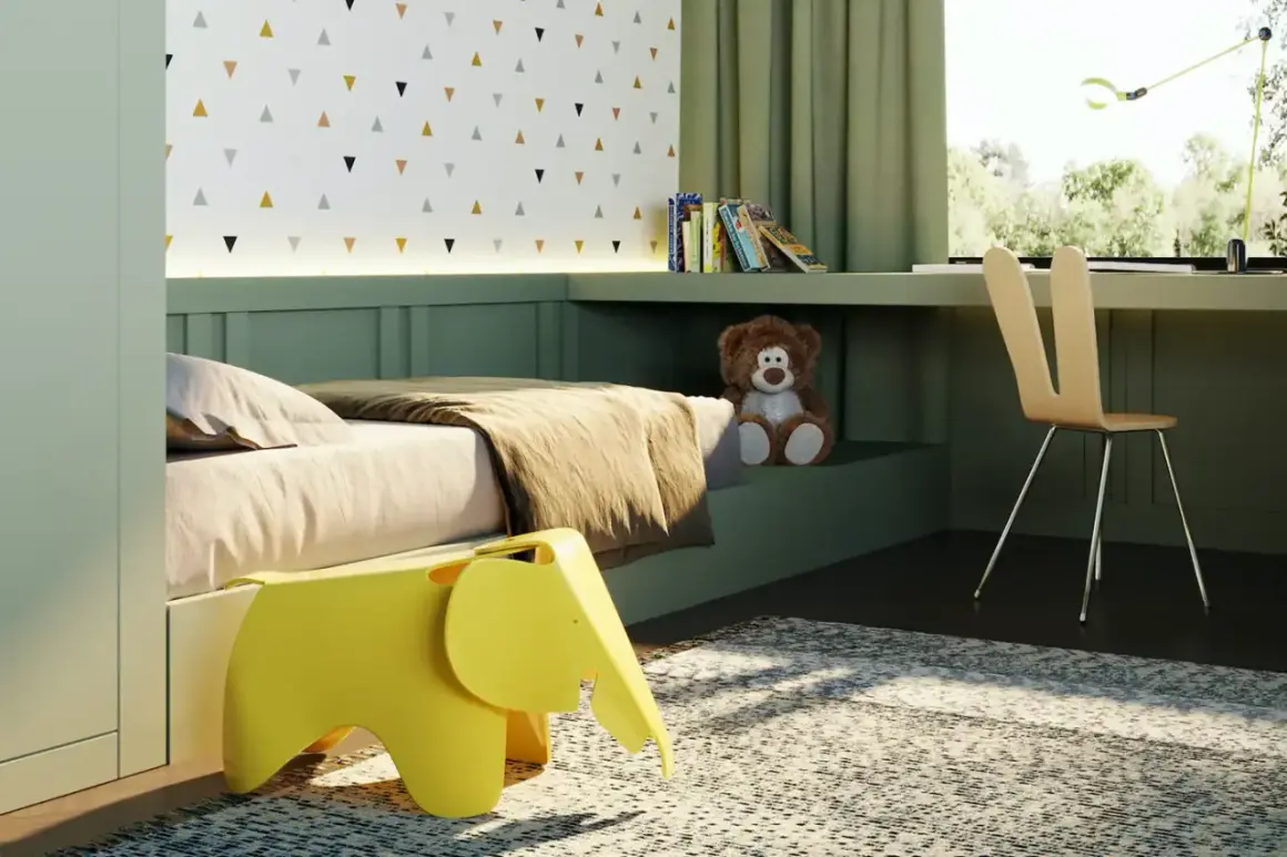 Arredamento camera neonato: letto accogliente, sgabello a forma di elefante giallo, orsacchiotto e scrivania con vista sul verde.