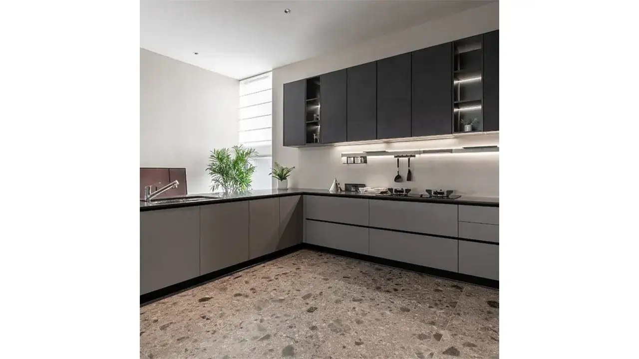Elegante cucina due colori con pensili grigio scuro e basi color tortora. Pavimento in graniglia e piano di lavoro nero.