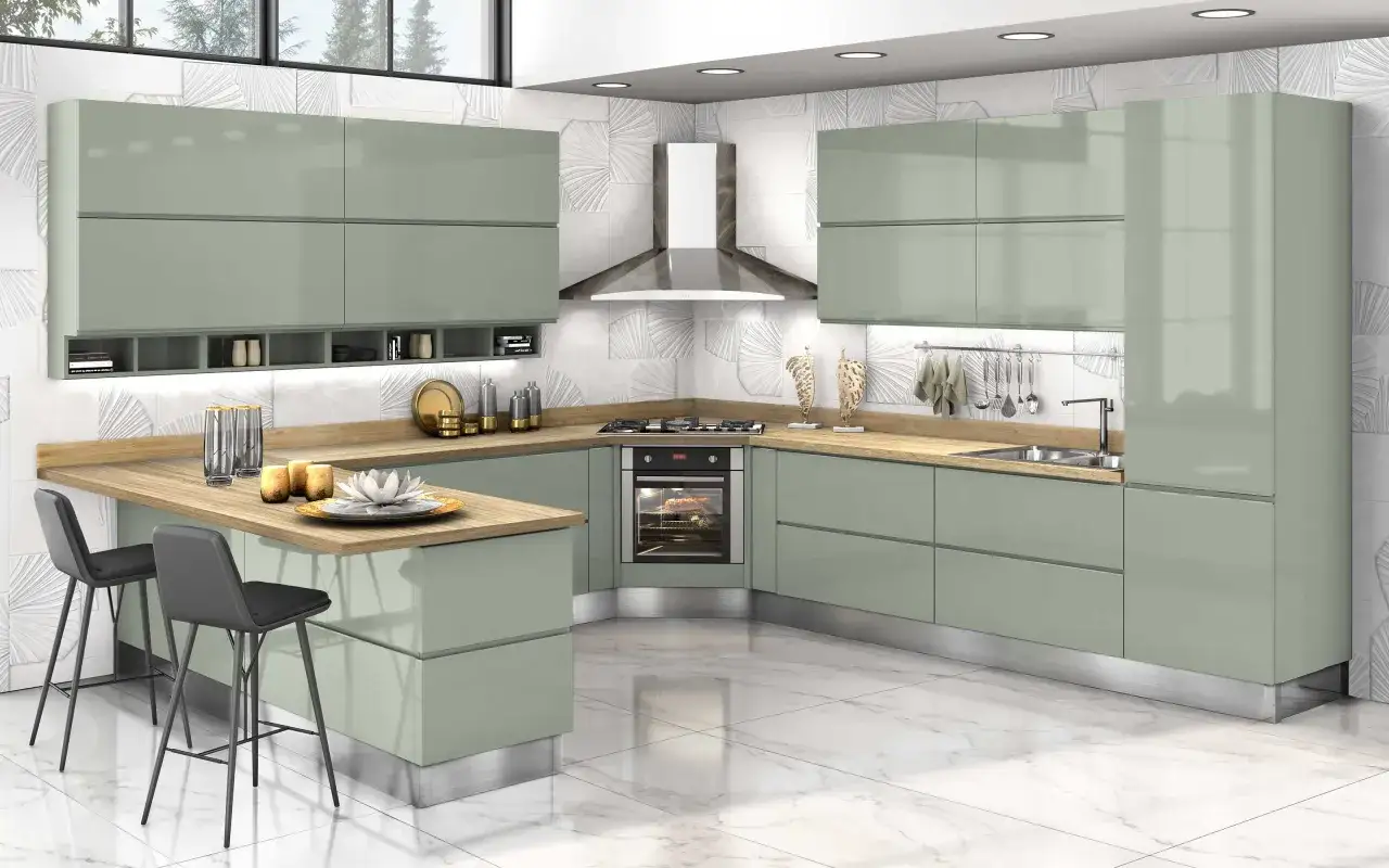 Elegante cucina verde malva con isola, bancone snack, elettrodomestici a vista e finiture moderne.