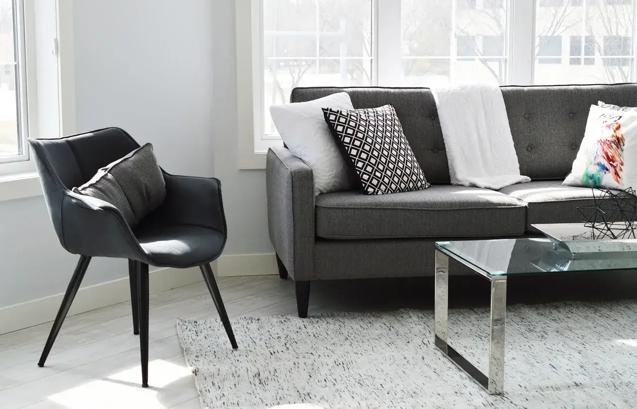 Divano grigio scuro con cuscini che creano abbinamenti perfetti: geometrico, bianco testurizzato e colorato.