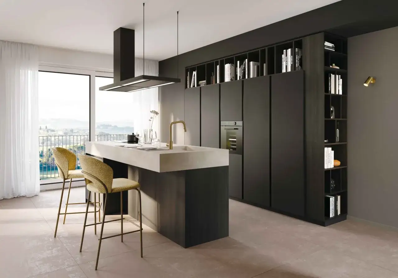 Moderna cucina con isola centrale, sgabelli dorati e pensili a giorno pieni di libri. Un esempio di idee cucina nera e legno per un ambiente sofisticato.