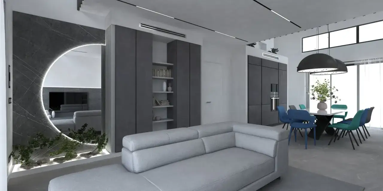 Soggiorno moderno con divano grigio, specchio circolare illuminato e zona pranzo con sedie blu e verdi, creando un mix di colori che si abbinano con il grigio.