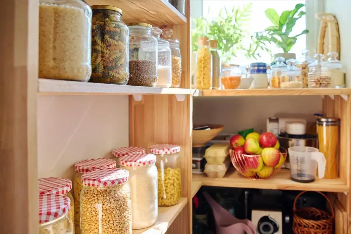 Dispensa organizzata con barattoli di pasta, riso, legumi e frutta fresca. Un esempio di come organizzare dispensa in modo ordinato e funzionale.
