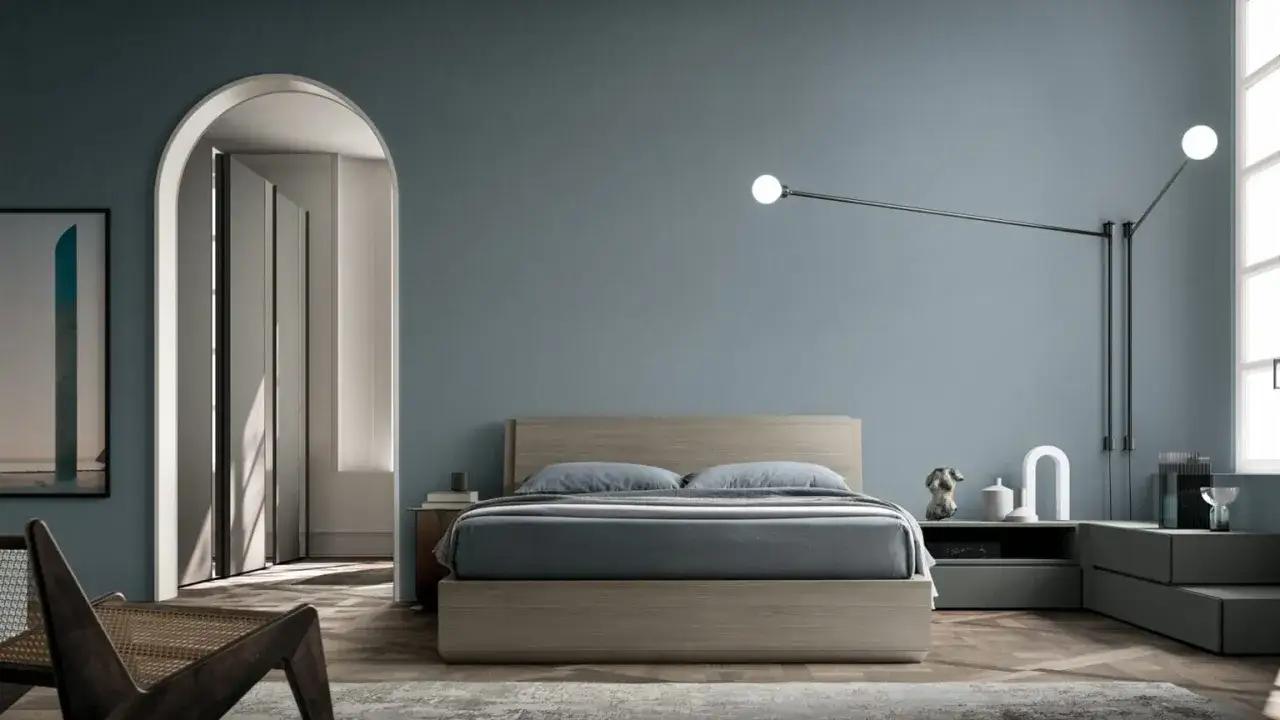 Camera da letto moderna con letto in legno, pareti blu polvere e un'elegante lampada a sospensione. Idee per pareti camera da letto moderna.