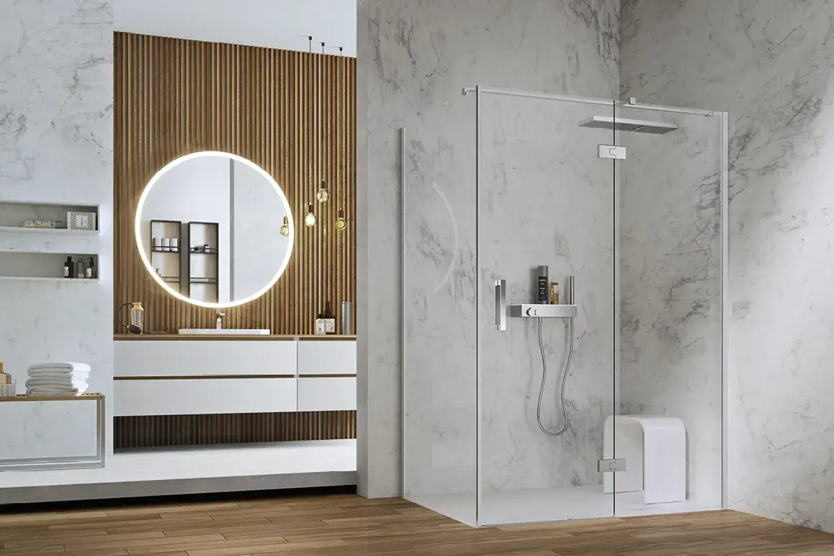 Bagno moderno con doccia in cristallo, specchio rotondo illuminato e mobile lavabo. Idee doccia bagno per un ambiente di design.