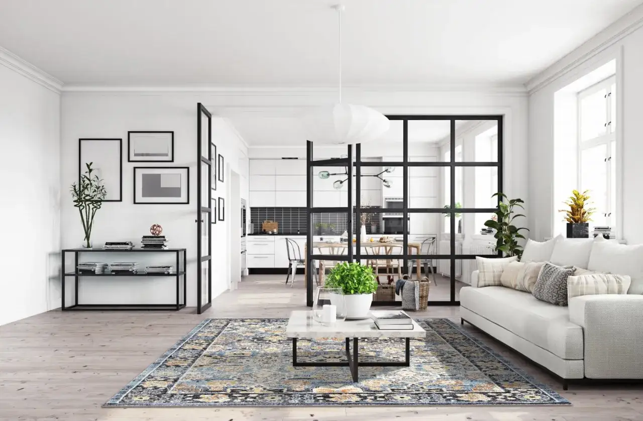 Un soggiorno moderno con divisori in vetro nero che separano la zona giorno dalla cucina, offrendo idee per dividere zona giorno da zona notte con stile.