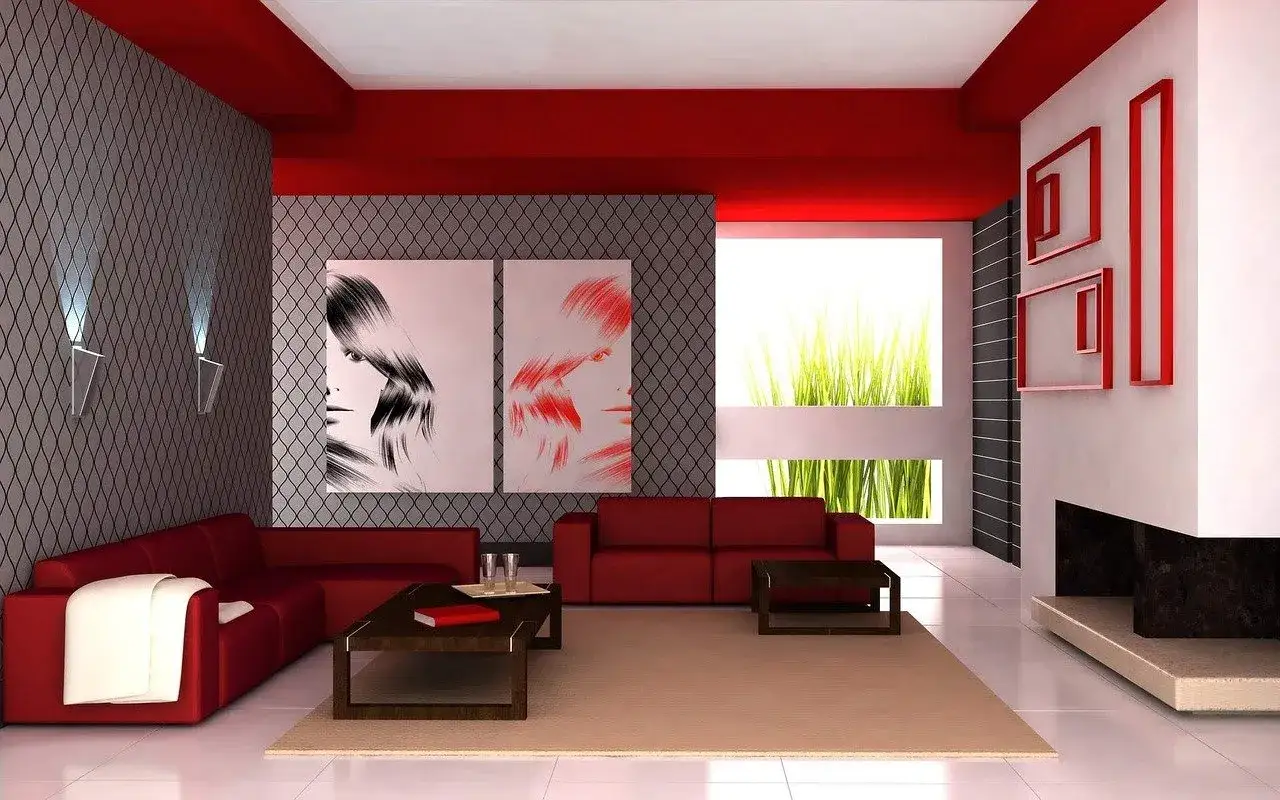 Soggiorno moderno con divani rossi, quadri di volti stilizzati e un tocco di viva magenta nel soffitto e nelle cornici.