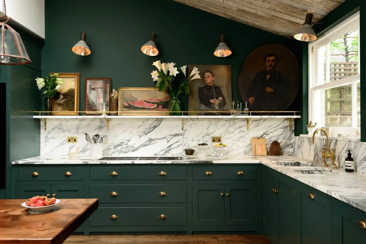 Cucina con eleganti pareti cucina verde oliva, marmo bianco e mobili scuri.