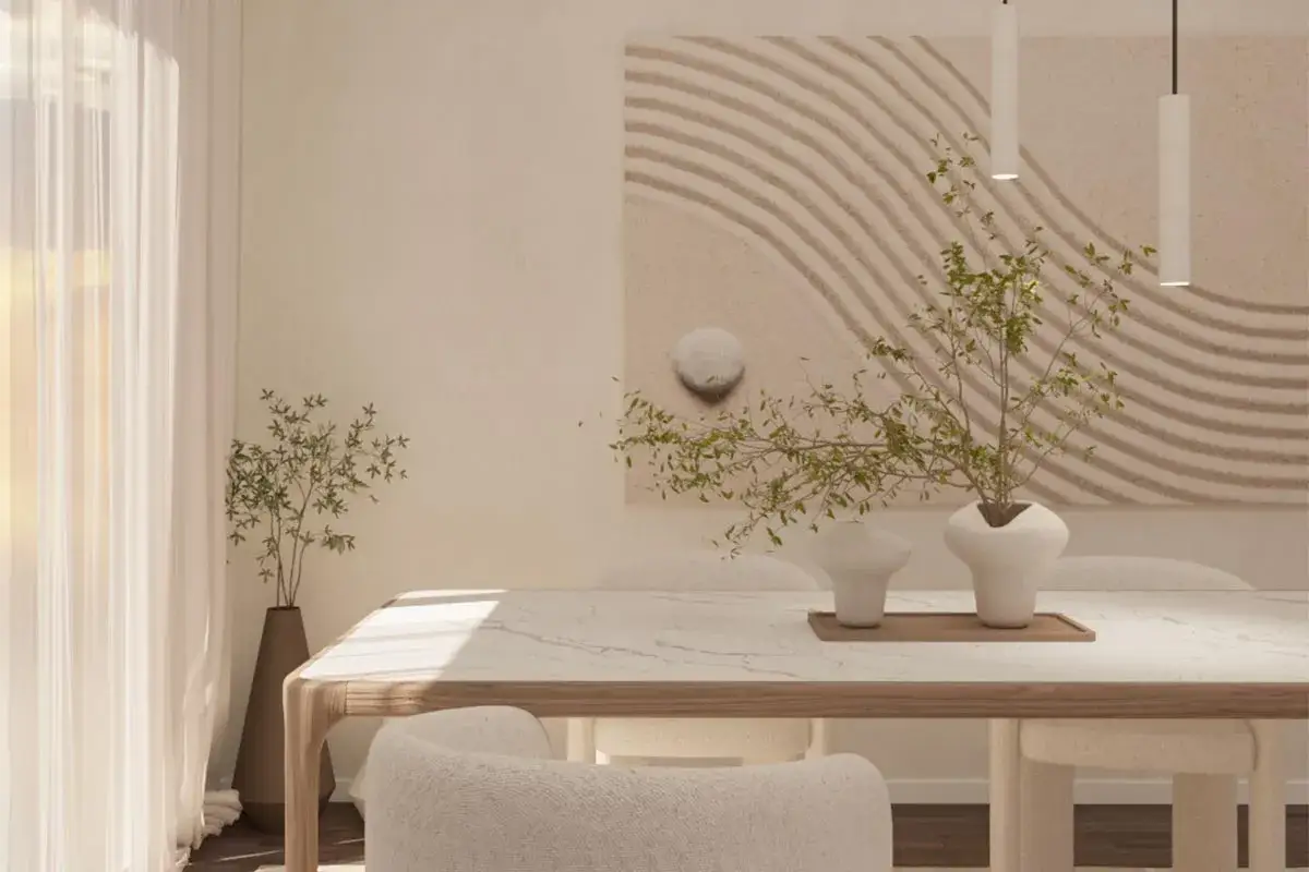 Un tavolo in marmo e legno, sedie morbide e un quadro con onde sabbiose definiscono questo ambiente in stile japandi.