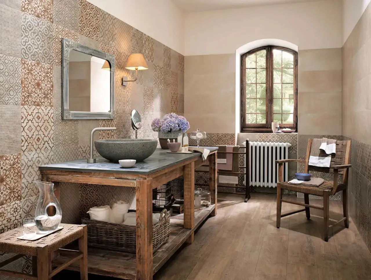 Bagni stile rustico con lavabo in pietra, specchio anticato e pareti decorate con piastrelle effetto tessuto.