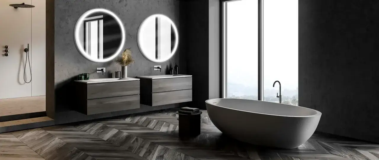 Bagno moderno con pavimenti in legno scuro, mobili sospesi color legno e specchi rotondi illuminati. Un'elegante vasca da bagno freestanding domina la scena, perfetta per idee bagno nero e legno.