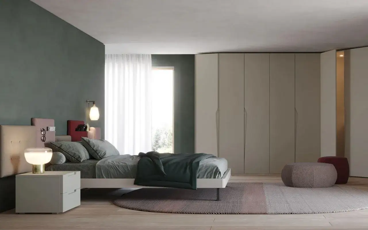 Camera da letto con pareti verdi e armadi beige. Cuscini e coperta verde scuro creano un'atmosfera rilassante, mostrando i colori che stanno bene con il verde.