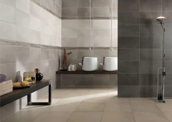 Moderne idee bagno con gres porcellanato effetto pietra. Due lavabi sospesi, un mobile con profumi e asciugamani.