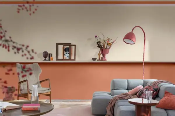 Soggiorno con pareti color pesca e beige, un divano grigio e una poltrona vintage. Idee pareti colorate particolari per un ambiente accogliente.