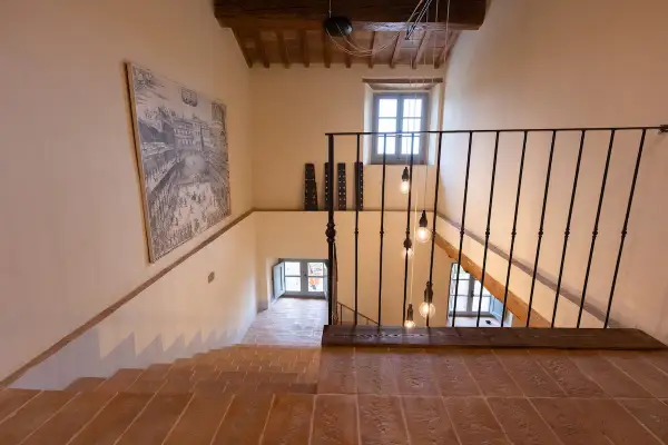 Scala interna con gradini in cotto e un grande quadro. Ottime idee pittura scala interna per un tocco artistico.