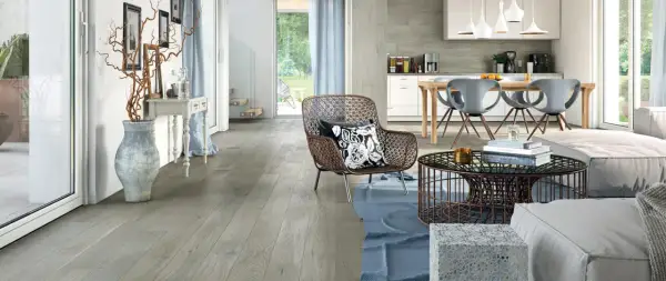 Soggiorno e cucina moderni con pavimento grigio chiaro, mobili di design e un'ampia vetrata sul giardino.