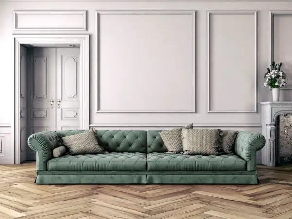 Divano verde bosco con cuscini beige, abbinamenti eleganti in un salotto classico con parquet.