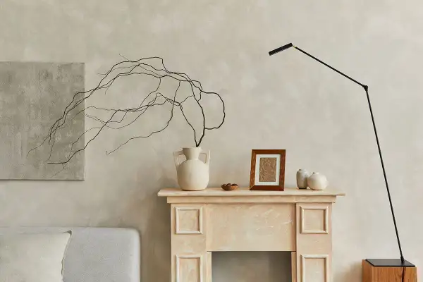 Un camino decorato con vasi, un quadro e rami secchi, perfetto per decorare una parete spoglia.