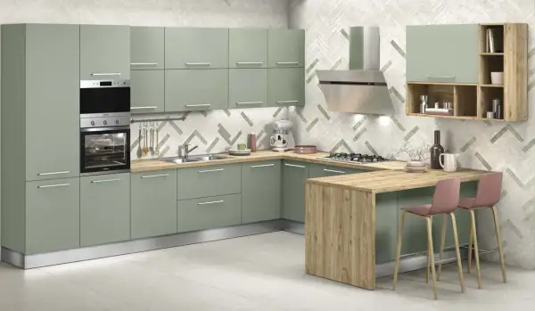 Elegante cucina verde malva con isola in legno, elettrodomestici in acciaio e sgabelli rosa.
