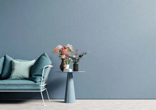 Divano turchese e tavolino con fiori su sfondo blu polvere, un'ispirazione per una moderno pittura cameretta.