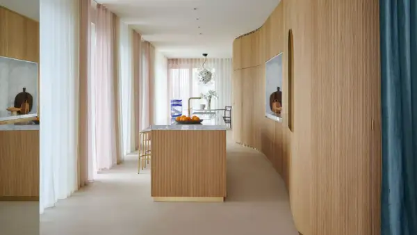 Ingresso con boiserie moderne in legno, isola cucina e tende colorate.