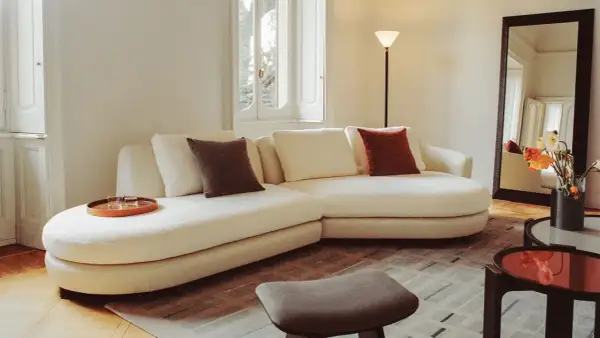 Soggiorno accogliente con divano bianco, cuscini colorati e vassoio. Un esempio di come fare decluttering per un ambiente sereno.