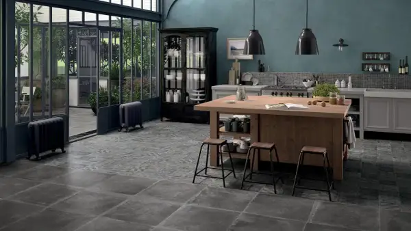 Cucina con isola in legno, sgabelli, vetrata e pavimenti con idee piastrelle cucina effetto pietra e decoro vintage.