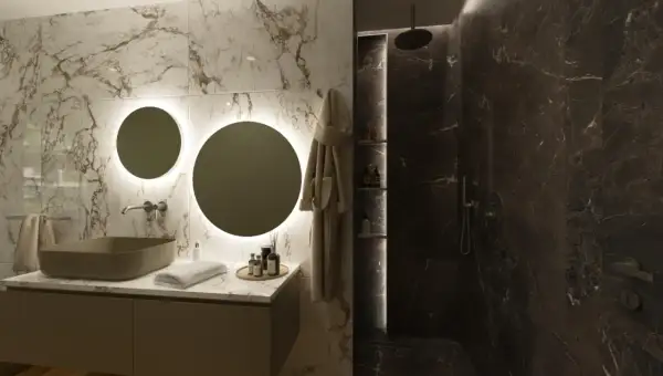 Elegante bagno scuro moderno con lavabo in pietra, specchi rotondi illuminati e doccia in marmo scuro.