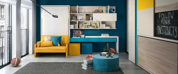 Camera ragazzo 14 anni: divano giallo, scrivania blu, libreria con oggetti sportivi e una lavagna con la scritta "Follow your instincts".